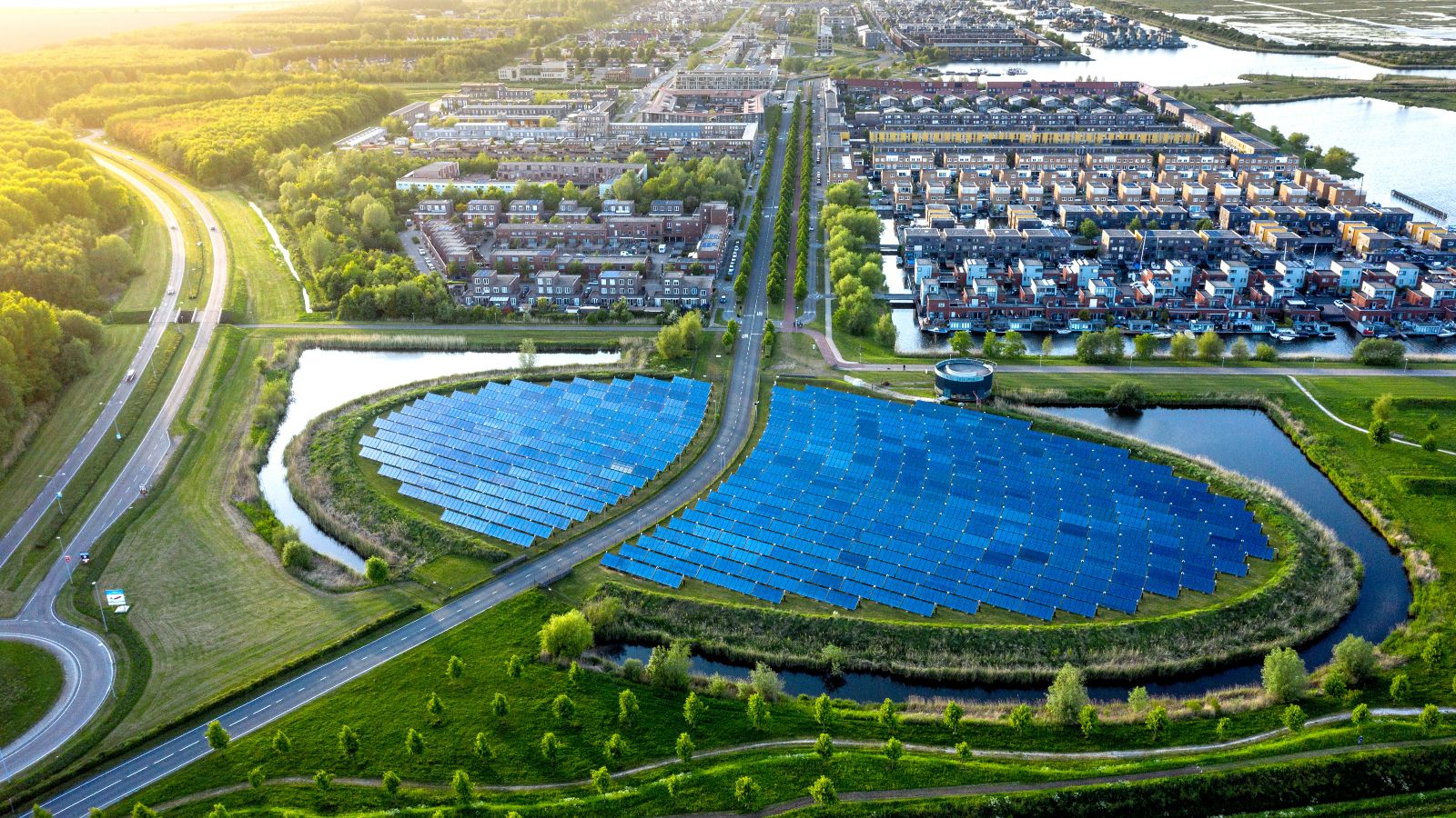 Luftaufnahme eines modernen, nachhaltigen Viertels in Almere, Niederlande. Eine große, runde Ansammlung von Solaranlagen ist im Zentrum zu sehen.