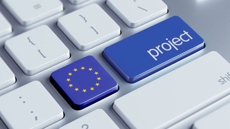 Bild einer Tastatur. Eine Taste ist mit der EU-Flagge eingefärbt, die Taste daneben ist blau eingefärbt, darauf mit weißer Schrift das englische Wort Project.