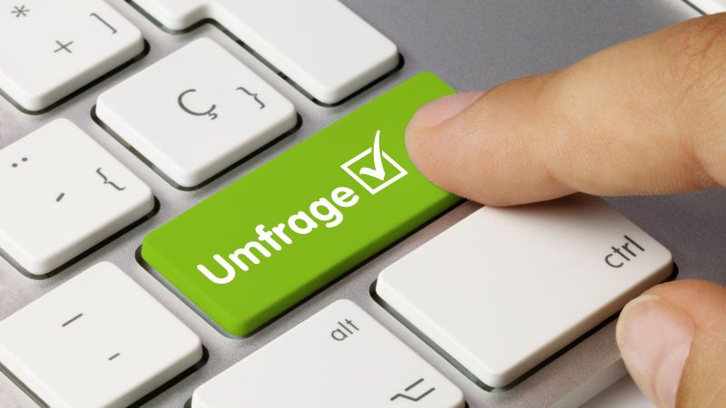 Ein Zeigefinger drückt auf einer Tastatur auf eine grüne Taste mit der Aufschrift 