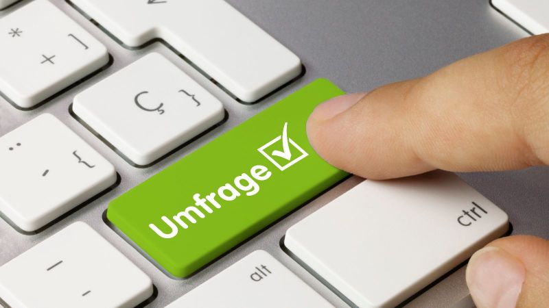 Ein Zeigefinger drückt auf einer Tastatur auf eine grüne Taste mit der Aufschrift 