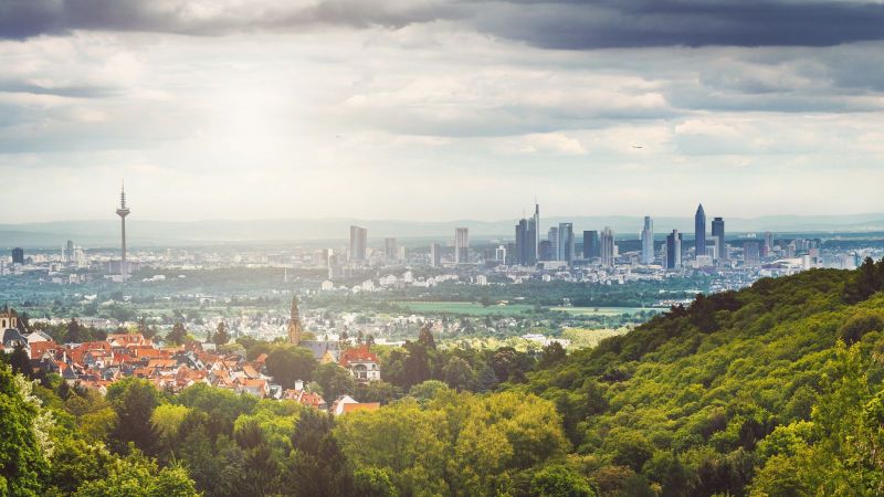 Blick auf Stadtpanorama mit vielen Parks über die Stadt verteilt. Dicht bewölkter Himmel