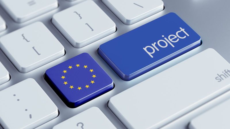 Bild einer Tastatur. Eine Taste ist mit der EU-Flagge eingefärbt, die Taste daneben ist blau eingefärbt, darauf mit weißer Schrift das englische Wort Project.