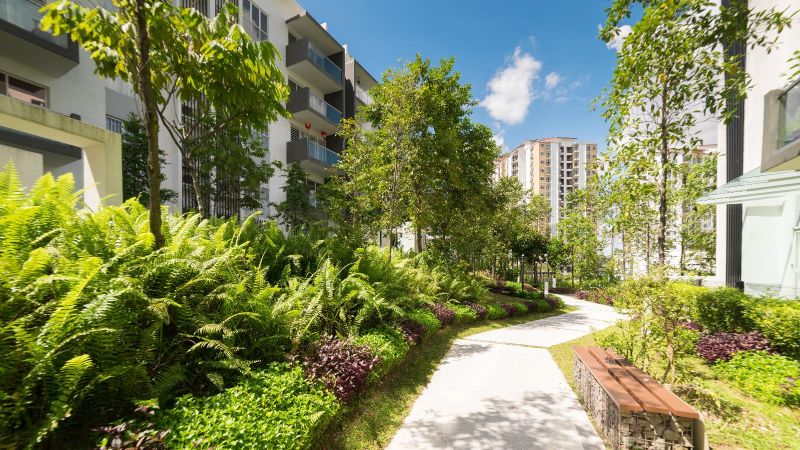 Weg durch begrünte Häuseranlage.