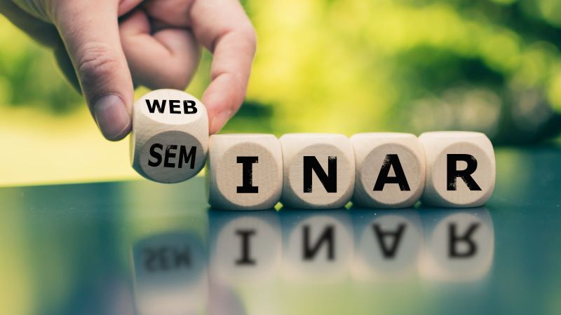 Eine Hand platziert einen Würfel, von dem die zwei Seiten 