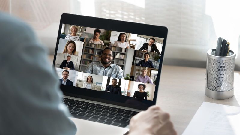 Ein Zuhörer sitzt vor einem Laptop mit einem Online-Meeting.