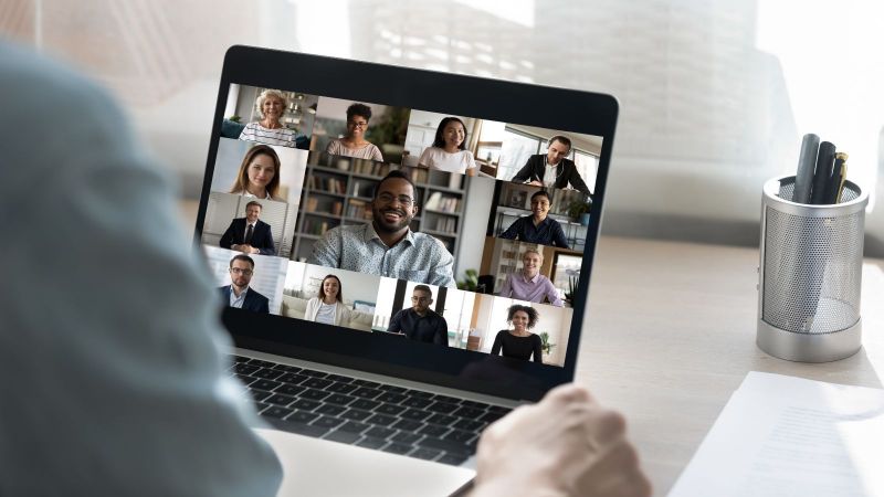 Ein Zuhörer sitzt vor einem Laptop mit einem Online-Meeting.