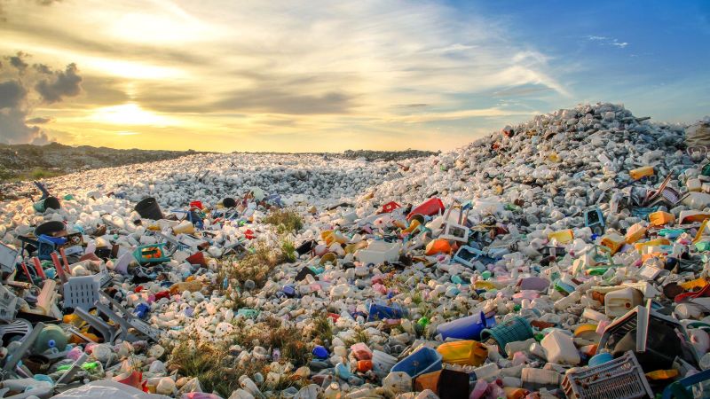 Plastikmüll füllt eine Deponie, die sich bis zum Horizont erstreckt.