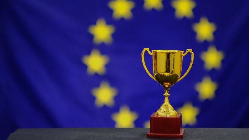 Trophäe mit der Flagge der Europäischen Union im Hintergrund.