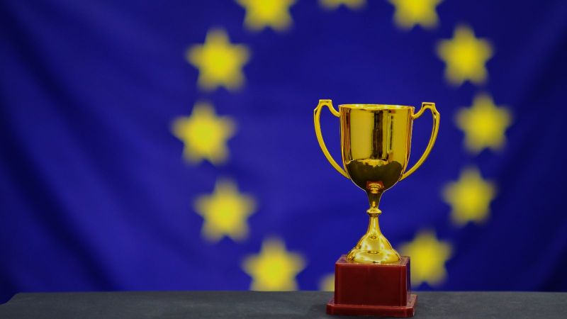 Trophäe mit der Flagge der Europäischen Union im Hintergrund.