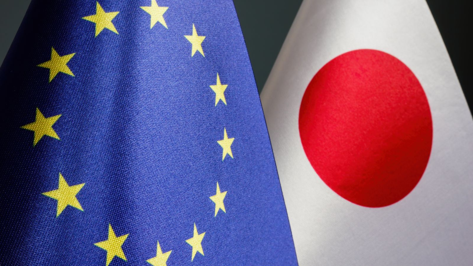 Nahaufnahme einer Europäischen und einer japanischen Flagge.