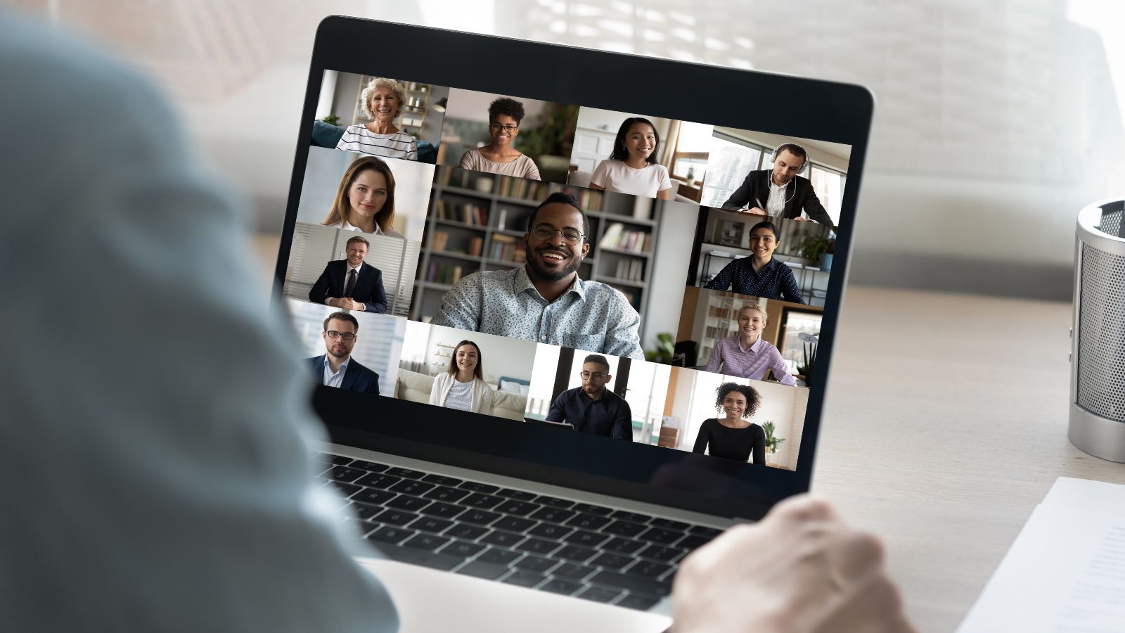 Ein Zuhörer sitzt vor einem Laptop mit einem Online-Meeting.