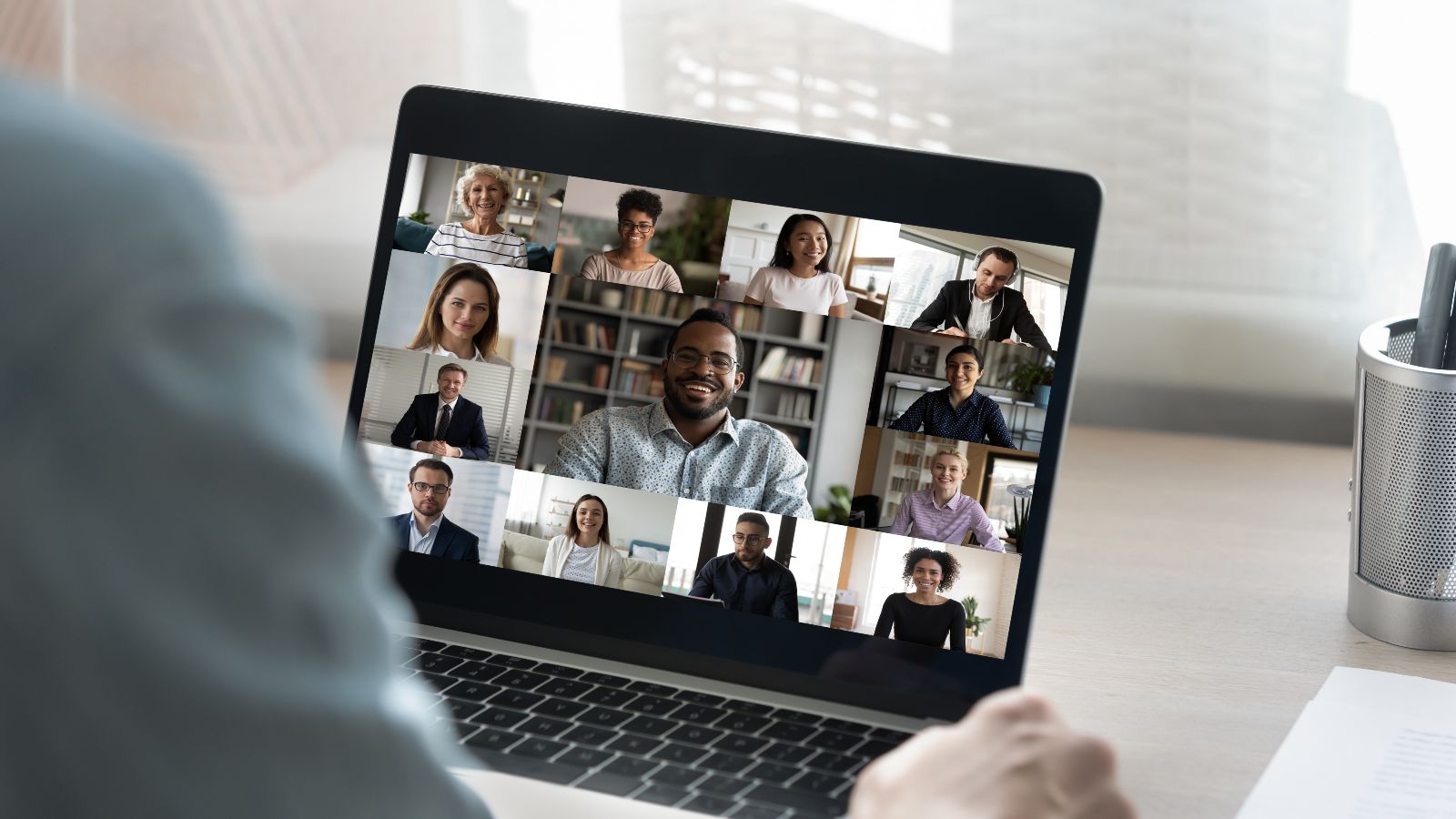 Ein Zuhörer sitzt vor einem Laptop mit einem Online-Meeting.