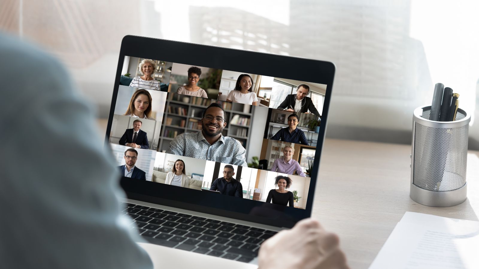 Ein Zuhörer sitzt vor einem Laptop mit einem Online-Meeting.