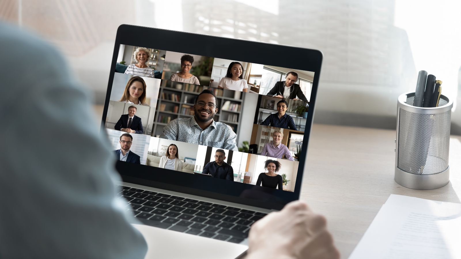 Ein Zuhörer sitzt vor einem Laptop mit einem Online-Meeting.