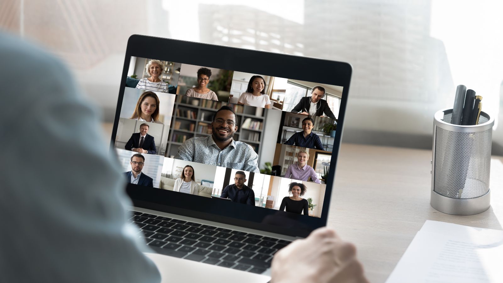 Ein Zuhörer sitzt vor einem Laptop mit einem Online-Meeting.