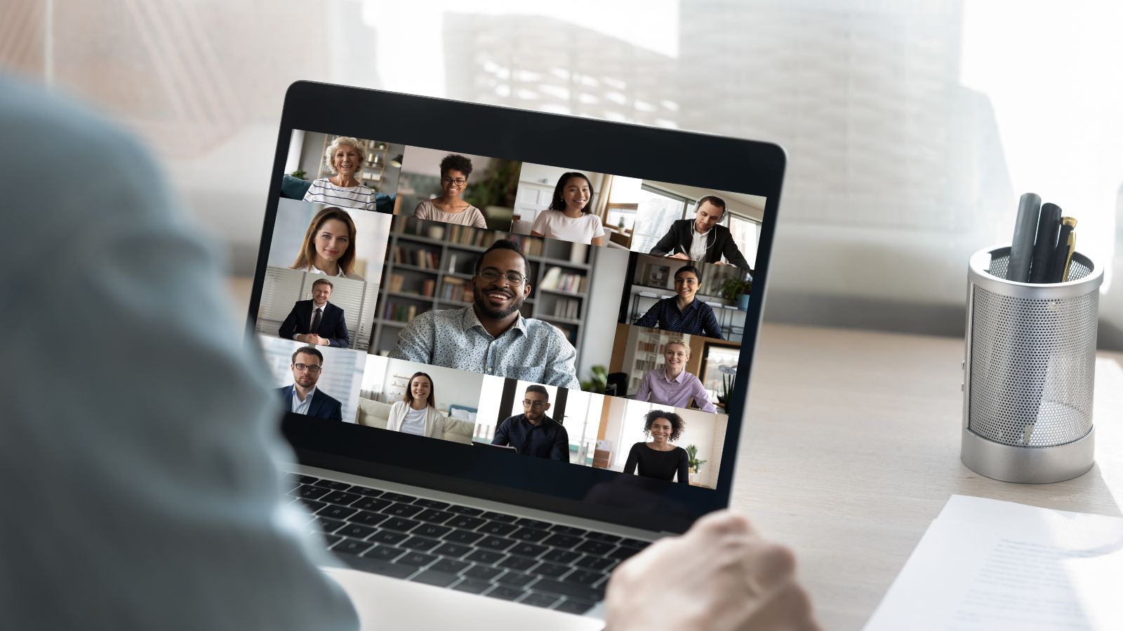 Ein Zuhörer sitzt vor einem Laptop mit einem Online-Meeting.