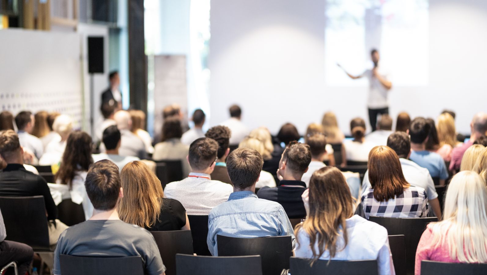 Bild eines Konferenzvortrages mit Blick auf den Sprecher auf dem Podium.