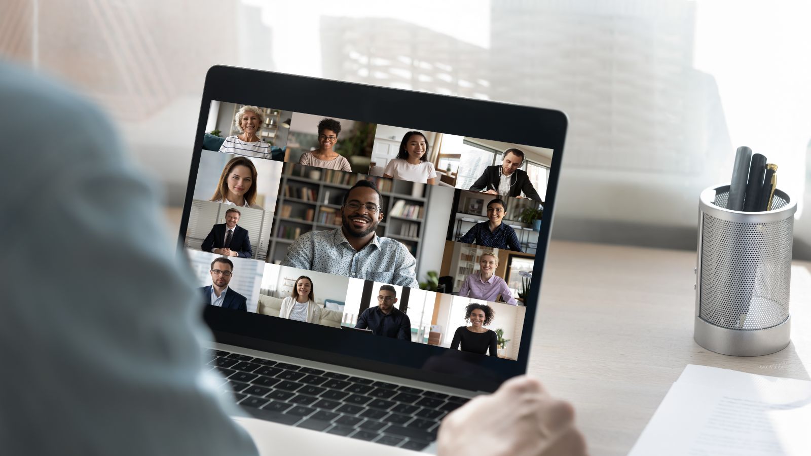 Ein Zuhörer sitzt vor einem Laptop mit einem Online-Meeting.