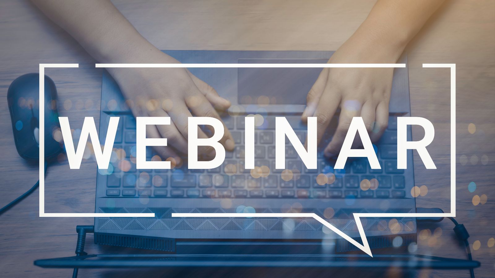 Das Wort Webinar ist über das Photo eines Laptops mit Händen aus der Vogelperspektive gelegt.