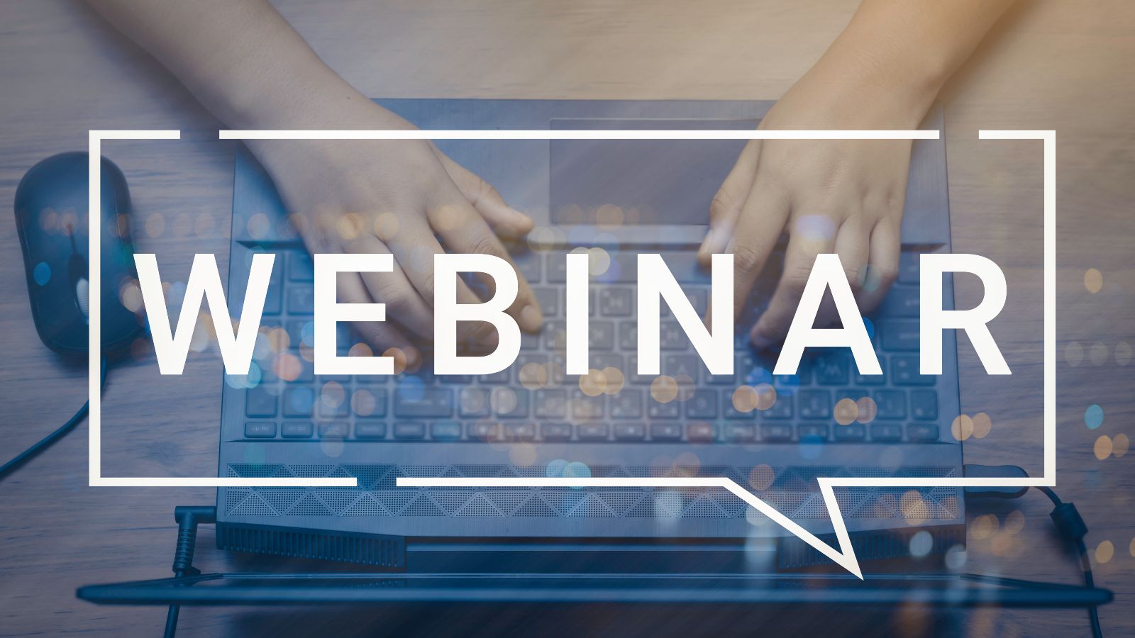 Das Wort Webinar ist über das Photo eines Laptops mit Händen aus der Vogelperspektive gelegt.