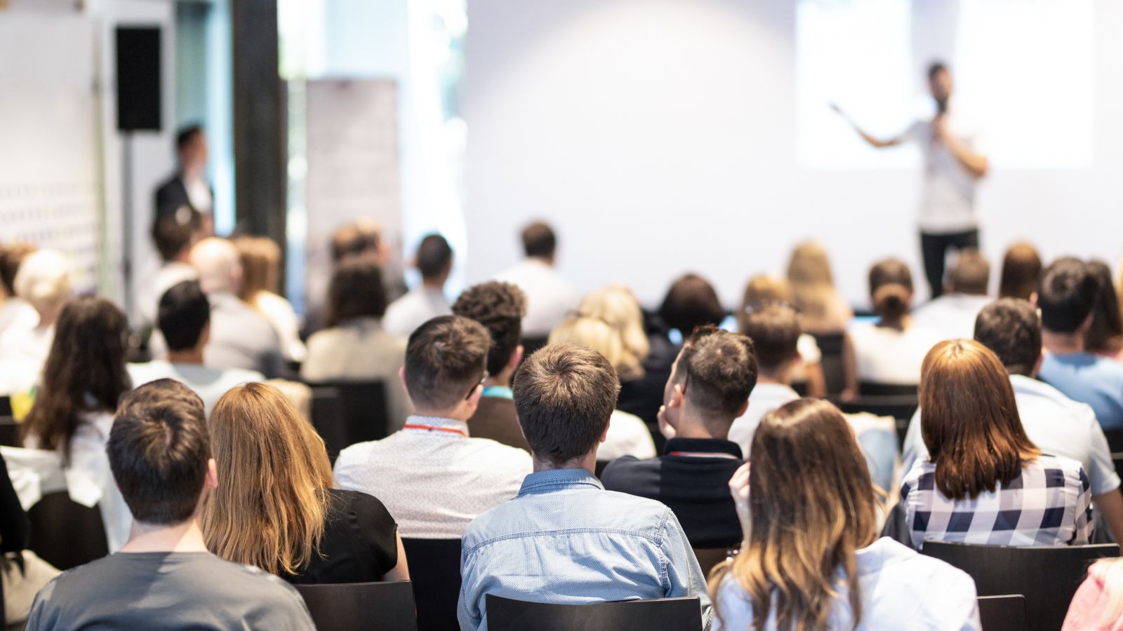 Bild eines Konferenzvortrages mit Blick auf den Sprecher auf dem Podium.
